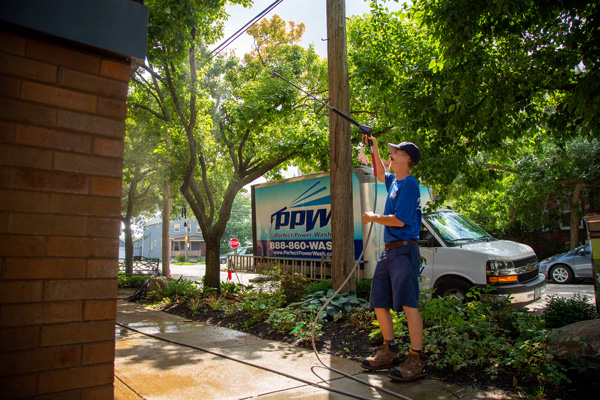 Member of Perfect Power Wash's Dream Team washing the exterior of Malachi House in Cleveland, OH
