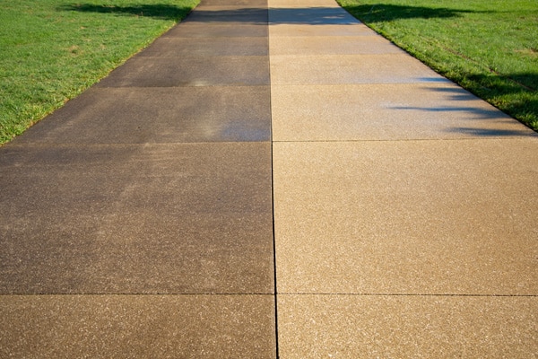 Half-washed driveway showing the before and after results of power washing concrete