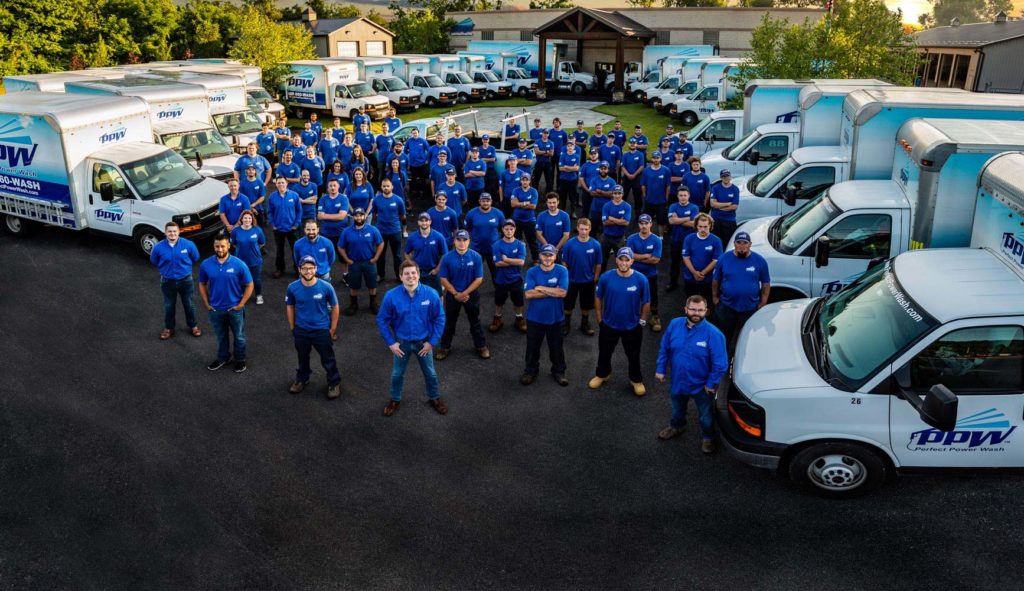 About us: Perfect Power Wash employees surrounded by company trucks and office building