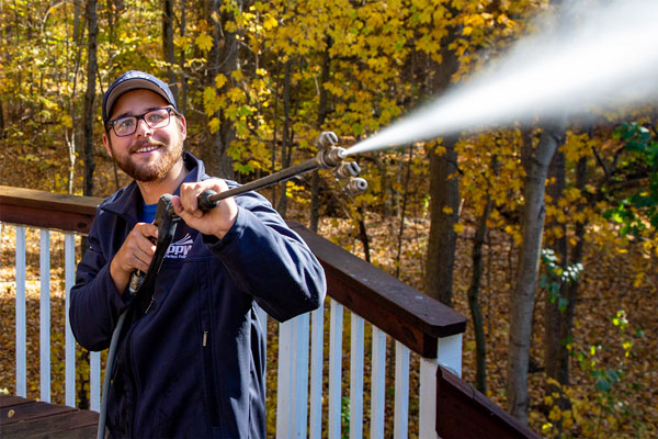Image of a Perfect Power Wash technician washing a house