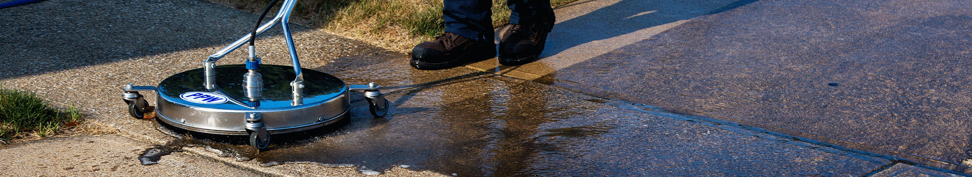 A surface cleaner with a PPW sticker cleaning a concrete driveway, showing before and after
