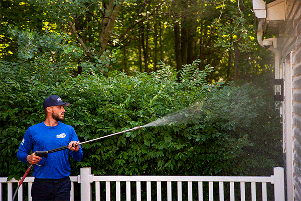 Perfect Power Wash employee cleaning siding