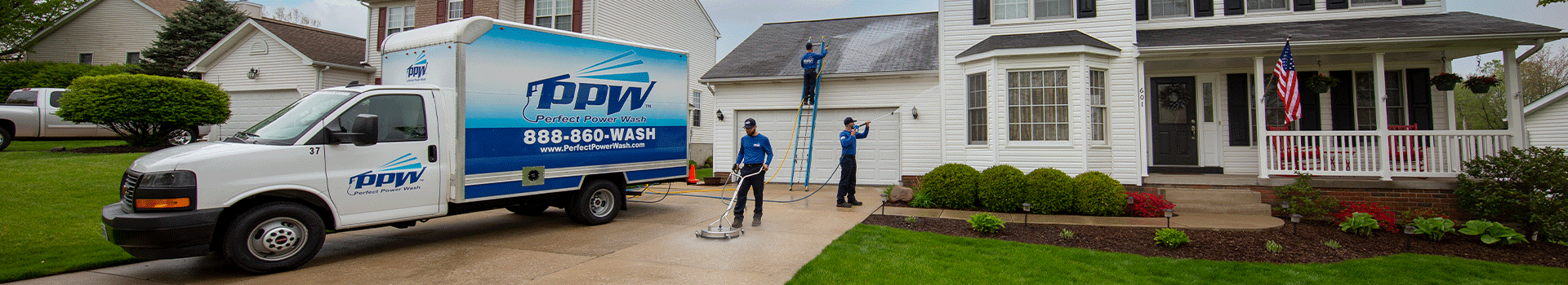 Three Perfect Power Wash technicians cleaning a driveway, house, and roof