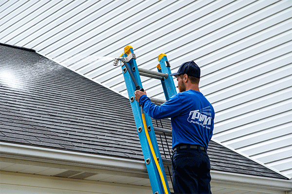Perfect Power Wash technician performing a roof treatment